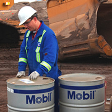 Worker With Barrels Of Mobil Oil